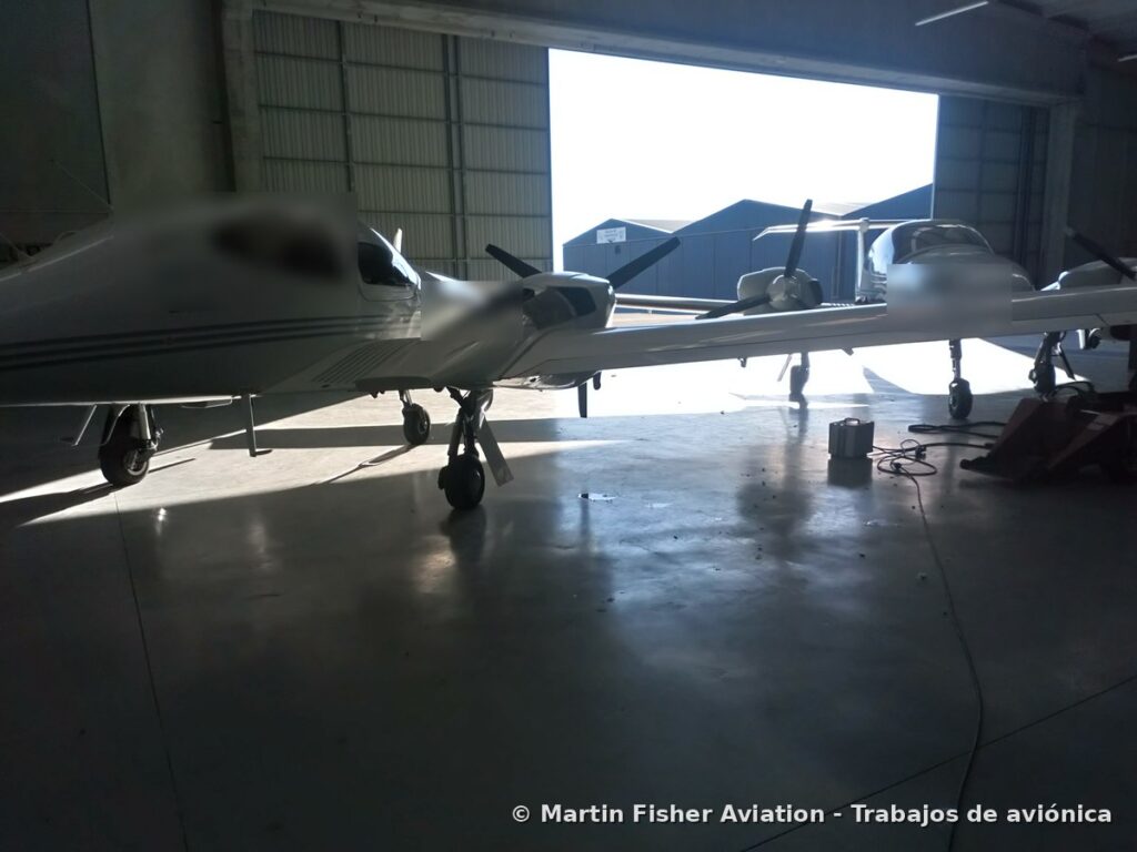 Aeronaves en hangar con equipos de tierra y cables sobre el suelo, entorno típico de inspección FOD