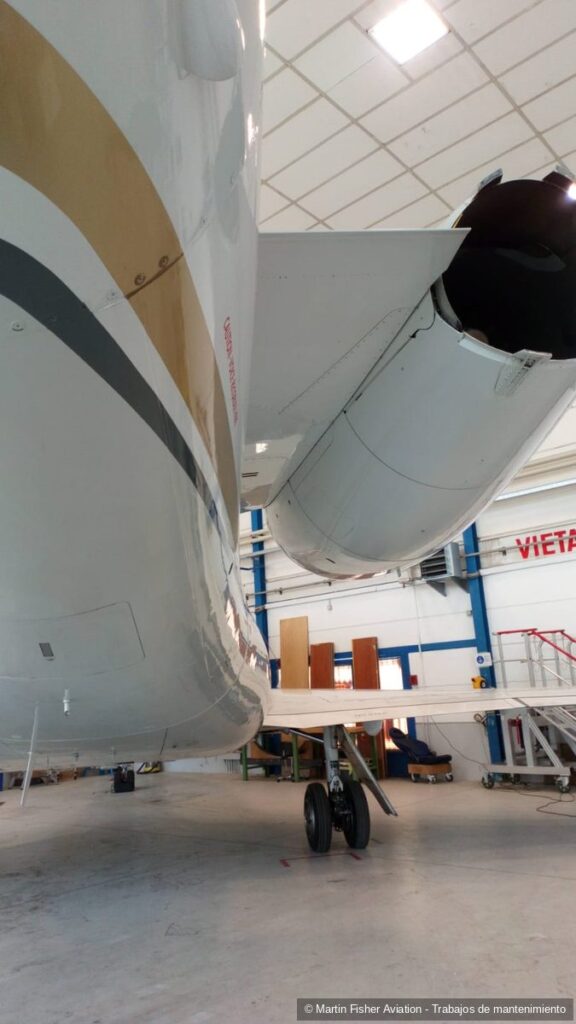 Detalle del encastre del ala y la góndola del motor de un reactor en hangar