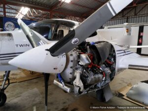 Motor de una aeronave bimotor descarenado en hangar durante una inspección