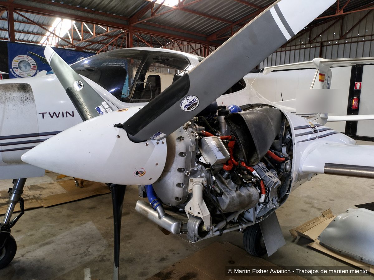 Motor de una aeronave bimotor descarenado en hangar durante una inspección